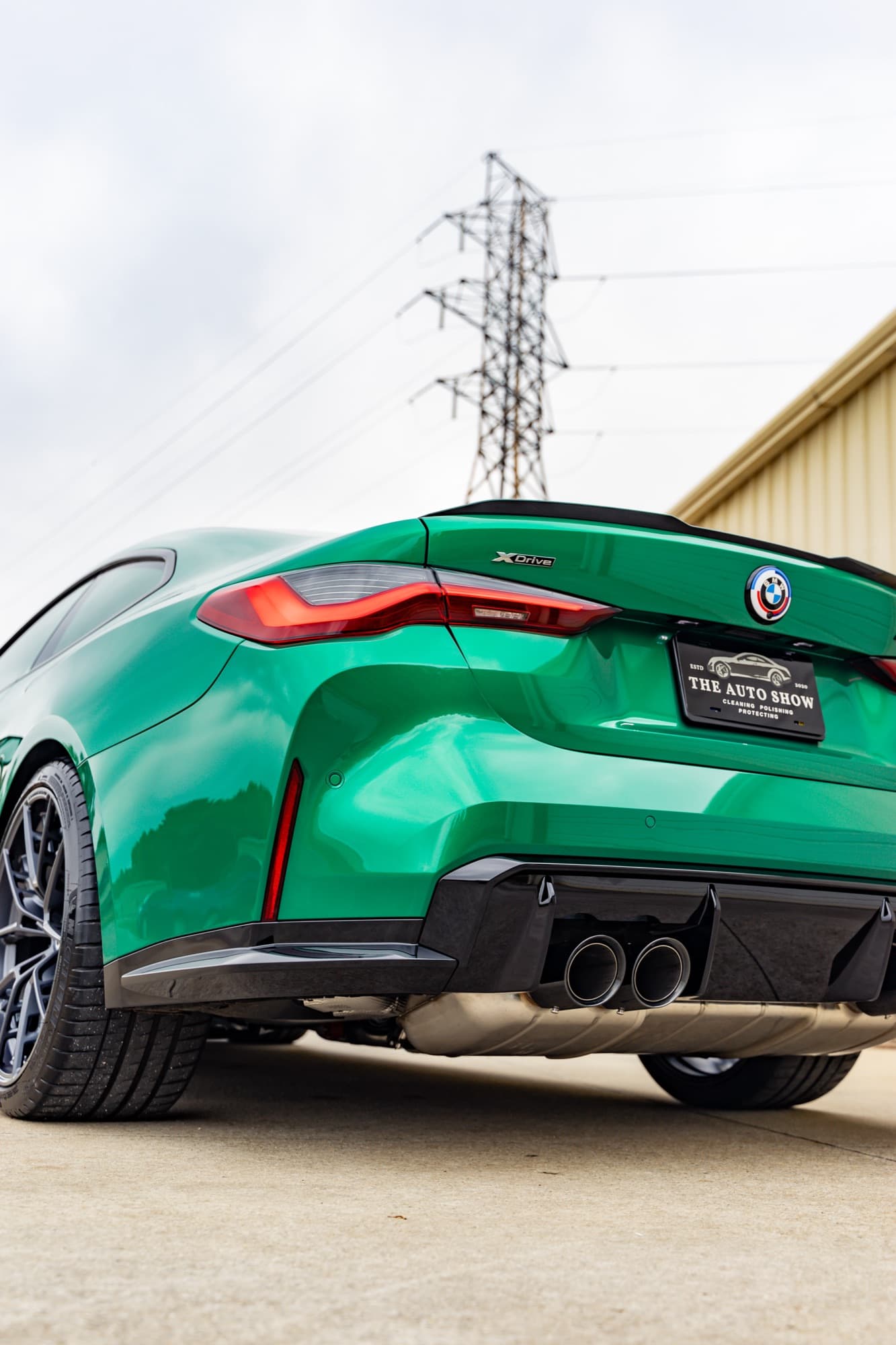 The rear of a glossy green BMW M4