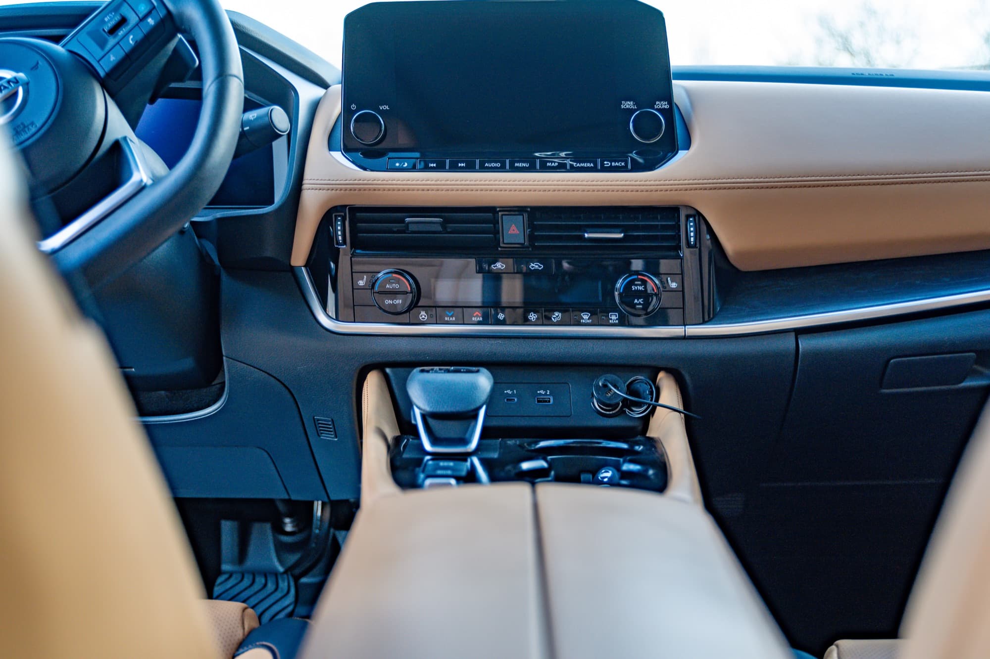 A car dashboard with a center touchscreen and tan trim