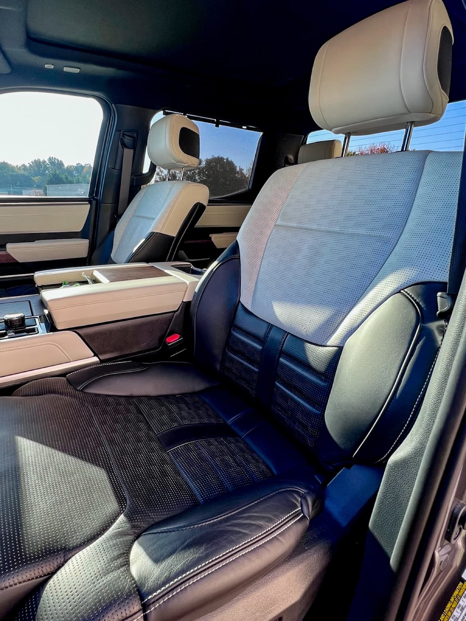 Gray and black leather front seats in a truck, with sunlight coming through the side windows